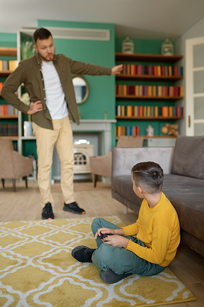 Parent scolding child addicted to modern technologies at home. Father forcing son go for walk instead of watching or playing games on smartphone